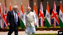Indian Prime Minister Narendra Modi talks with his British counterpart Boris Johnson before their delegation level talks in New Delhi, April 22, 2022. 