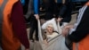 Klavidia, 91, is carried on an improvised stretcher as she flees the war by boarding a train in Pokrovsk, Ukraine, on April 25, 2022.