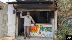 FILE - Nawab Khan stands by the entrance of his shop vandalized by a mob on April 10 in Khargone, in the central Indian state of Madhya Pradesh, April 12, 2022.