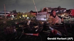 FILE - A car is flipped over after a tornado tore through the area in Arabi, Louisiana on March 22, 2022, in a part of the city that had been heavily damaged by Hurricane Katrina 17 years earlier. (AP Photo/Gerald Herbert, File)
