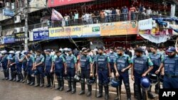 ঢাকা কলেজের ছাত্র এবং নিউমার্কেট ব্যবসায়ীদের মধ্যে সংঘর্ষের একদিন পর ঢাকার নিউ মার্কেটে শপিং সেন্টারের সামনে পুলিশ সদস্যরা পাহারা দিচ্ছেন। (ছবি মুনির উজ জামান/এএফপি)