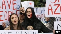 Activists hold banners during a meeting to urge foreign leaders and international organizations to help provide humanitarian corridors for evacuation of civilians and Ukrainian servicemen from Mariupol, in central Kyiv, April 27, 2022, amid Russia's invasion of Ukraine.