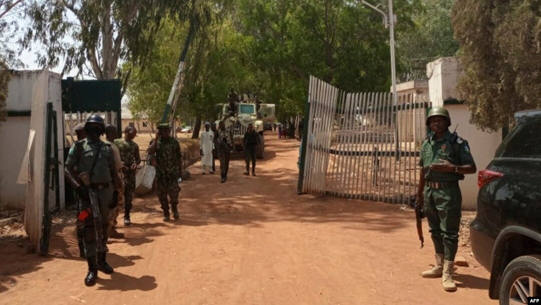 FILE - Nigerian soldiers and police officers stand at the entrance of a school in Kaduna state, on March 12, 2021, after a mass abduction. Family members report that on March 7, 2024, dozens of students were kidnapped from a school in the town of Kuriga. 