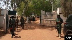 FILE - Nigerian soldiers and police officers stand at the entrance of a school in Kaduna state, on March 12, 2021, after a mass abduction. Family members report that on March 7, 2024, dozens of students were kidnapped from a school in the town of Kuriga. 