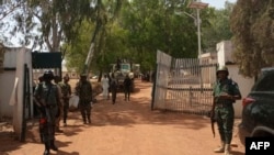 FILE - Nigerian soldiers and police officers stand at the entrance of a forestry college in Kaduna State on March 12, 2021, after a kidnapping gang stormed the school.