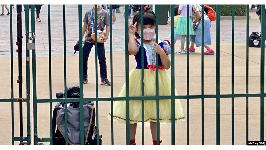 打扮成白雪公主的小女孩在香港迪士尼乐园大闸外等候入场 (美国之音/汤惠芸)