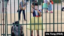 打扮成白雪公主的小女孩在香港迪士尼樂園大閘外等候入場。(美國之音/湯惠芸)