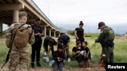A Customs and Border Protection agent collects biographical information from a group of Venezuelan migrants before taking them into custody near the southern border town of Eagle Pass, Texas, April 25, 2022.