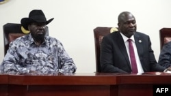 FILE - South Sudanese President Salva Kiir, left, and opposition leader Riek Machar attend the signing ceremony after the two leaders sealed an agreement on a key military provision of their faltering peace deal at the state house in Juba, April 3, 2022.