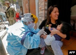 FILE - A health worker applies a vaccine against diphtheria to a baby in Lima, on Oct. 28, 2020.