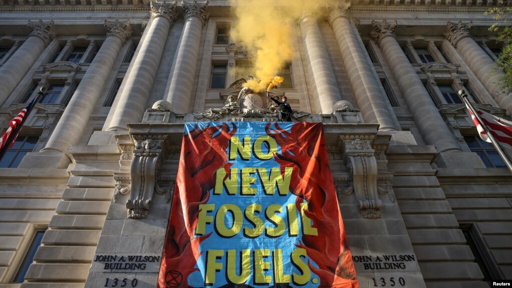 Activists from the climate group Extinction Rebellion demonstrate in front of the John Wilson District of Columbia government building to demand an end to all new fossil fuel infrastructure in Washington, U.S., April 22, 2022. (REUTERS/Evelyn Hockstein)