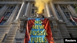 Activists from the climate group Extinction Rebellion demonstrate in front of the John Wilson District of Columbia government building to demand an end to all new fossil fuel infrastructure in Washington, U.S., April 22, 2022. (REUTERS/Evelyn Hockstein)