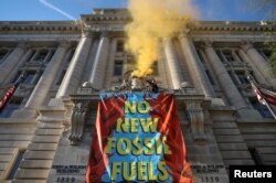 Activists from the climate group Extinction Rebellion demonstrate in front of the John Wilson District of Columbia government building to demand an end to all new fossil fuel infrastructure in Washington, U.S., April 22, 2022. REUTERS/Evelyn Hockstein