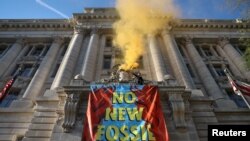 Sejumlah aktivis dari kelompok pemerhati isu iklim Extinction Rebellion menggelar aksi protes di depan gedung pemerintahan John Wilson District of Columbia di Washington, pada 22 April 2022, menuntut penghentian penggunaan energi fosil. (Foto: Reuters/Evelyn Hockstein)