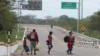Una familia venezolana recorre la autopista Panamericana tras dejar atrás Ecuador para entrar en Tumbes, Perú, el 30 de enero de 2021.