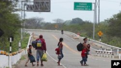 Una familia venezolana recorre la autopista Panamericana tras dejar atrás Ecuador para entrar en Tumbes, Perú, el 30 de enero de 2021.