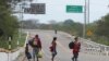 Migrantes venezolanos caminan por la Carretera Panamericana después de cruzar la frontera ecuatoriana hacia Tumbes, Perú, el sábado 30 de enero de 2021.