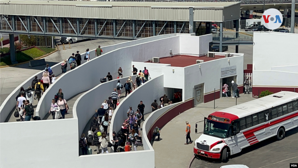 Uno de los primeros grupos de refugiados ucranianos en llegar a la garita de El Chaparral se baja de los autobuses movilizados desde la unidad deportiva Benito Juárez para ser procesados.(Tijuana, México-Abril 6, 2022-Celia Mendoza)