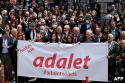 Demonstrators hold a banner reading in Turkish "Justice for all" during a protest against a Turkish court decision to sentence leading activist Osman Kavala to life in prison, in Istanbul, April 26, 2022.