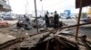 Los restos de un automóvil que explotó temprano en la mañana frente a una prisión en Guayaquil, Ecuador, se ven el 25 de abril de 2022, mientras la policía inspecciona la escena. 