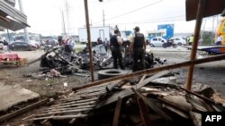 Los restos de un automóvil que explotó temprano en la mañana frente a una prisión en Guayaquil, Ecuador, se ven el 25 de abril de 2022, mientras la policía inspecciona la escena. 