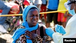 FILE - A young woman reacts as a health worker injects her with the Ebola vaccine, in Goma, Democratic Republic of Congo, Aug. 5, 2019.