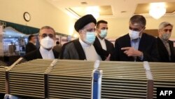 FILE - In this photo released by the official website of the office of the Iranian Presidency, President Ebrahim Raisi, center, visits an exhibition of Iran's nuclear achievements in Tehran, Iran, April 9, 2022. 