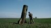 A Ukrainian serviceman looks at a Russian ballistic missile's booster stage that fell in a field in Bohodarove, eastern Ukraine, on April 25, 2022, amid the Russian invasion of Ukraine. 