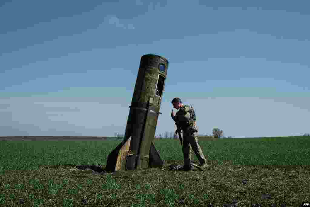 A Ukrainian serviceman looks at a Russian ballistic missile&#39;s booster stage that fell in a field in Bohodarove, eastern Ukraine, during the ongoing Russian invasion of Ukraine.