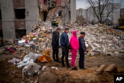 Residents look at their house destroyed by a Russian bomb in Chernihiv, April 22, 2022.