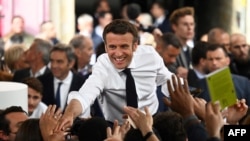 French President and candidate for reelection Emmanuel Macron shakes hands with supporters as he holds a rally on the last day of campaigning, in Figeac, southern France, April 22, 2022.