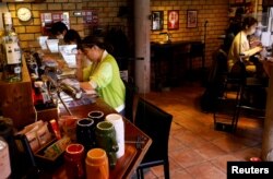 Para pelanggan mengerjakan manuskrip mereka di Manuscript Writing Cafe, Tokyo, Jepang, 21 April 2022. (REUTERS/Kim Kyung-Hoon)