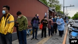 صف متقاضیان آزمایش کرونا در یک بیمارستان سرپایی در پکن، چین. ٢٧ آوریل ٢٠٢٢
