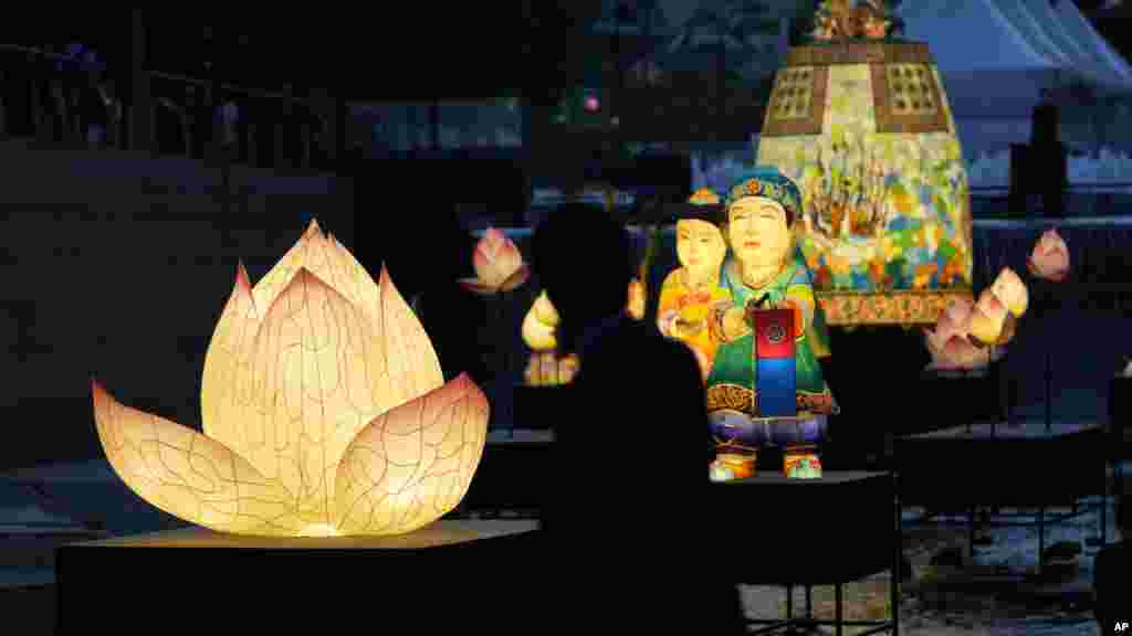 A visitor takes a photograph of lanterns displayed to celebrate for the upcoming birthday of Buddha at the public stream in Seoul, South Korea.