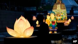 A visitor takes a photograph of lanterns displayed to celebrate for the upcoming birthday of Buddha at the public stream in Seoul, South Korea.