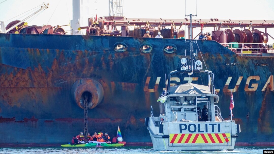Policijski brod pored gumenog čamca aktivista Grinpisa koji blokiraju ruski tanker "Ust Luga" nedozvoljavajući mu da istovari rusku naftu u norvešku luku, u znak protesta protiv ruske invazije na Ukrajinu, u blizini Asgardstranda, Norveška, 25. aprila 2022.