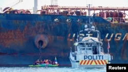 A police vessel sails near members of Greenpeace blocking a tanker 'Ust Luga' from delivering Russian oil to Norway as part of a protest against the Russia's invasion of Ukraine, according to Greenpeace, near Asgardstrand, Norway April 25, 2022.