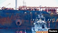 A police vessel sails near members of Greenpeace blocking a tanker 'Ust Luga' from delivering Russian oil to Norway as part of a protest against the Russia's invasion of Ukraine, according to Greenpeace, near Asgardstrand, Norway April 25, 2022.