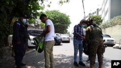 Soldados revisan las mochilas de residentes del barrio San José del Pino en Santa Tecla (El Salvador), el 6 de abril del 2022. Foto AP.