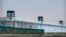 FILE - A person stands in a tower on the perimeter of the No. 3 Detention Center in Dabancheng in western China's Xinjiang Uyghur Autonomous Region on April 23, 2021. Human rights groups and Western nations have accused China of massive crimes against the Uyghur minority.