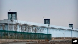 FILE - A person stands in a tower on the perimeter of the No. 3 Detention Center in Dabancheng in western China's Xinjiang Uyghur Autonomous Region, April 23, 2021. 