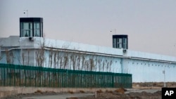 FILE - A person stands in a tower on the perimeter of the No. 3 Detention Center in Dabancheng, in China's Xinjiang Uyghur Autonomous Region, April 23, 2021. Rights groups have accused China of committing massive crimes against Uyghurs and other Turkic Muslim populations.