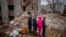 Residents look at their house destroyed by a Russian bomb in Chernihiv on April 22, 2022. 