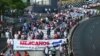 ARCHIVO - Miles de manifestantes salieron a las calles de San Salvador, el 1 de mayo de 2021, para protestar contra lo que ven como una deriva autoritaria y corrupción en el país, días después de que Estados Unidos sancionara a un colaborador del presidente Nayib Bukele.