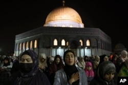 Umat Muslim Palestina melaksanakan salat tarawih di depan Masjid Kubah Batu, di kompleks Masjid Al Aqsa di Kota Tua Yerusalem, Rabu, 27 April 2022. (Foto: AP)