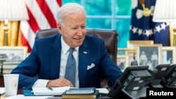 FILE - U.S. President Joe Biden speaks on the phone in the Oval Office of the White House in Washington, Sept. 22, 2021. (Adam Schultz/White House/handout via Reuters)