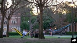 FILE - College students enjoy the outdoors at the University of Southern California campus in Los Angeles, March 1, 2022. College campuses throughout the U.S. are seeing a rise in COVID-19 cases. 