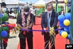 FILE - China's ambassador to the Solomon Islands Li Ming, right, and Solomon's Prime Minister Manasseh Sogavare cut a ribbon during the opening ceremony of a China-funded national stadium complex in Honiara, April 22, 2022.