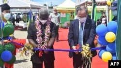 2022年4月22日，中国驻所罗门群岛大使李明(右)和所罗门总理索加瓦雷在霍尼亚拉中国资助的国家体育场开幕式上剪彩。