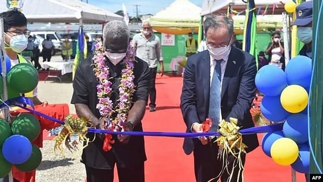 2022年4月22日，中國駐所羅門群島大使李明(右)和所羅門總理索加瓦雷在霍尼亞拉中國資助的國家體育場開幕式上剪彩。